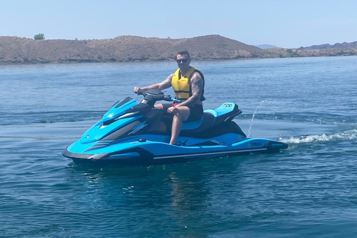 a man riding on the back of a boat in the water